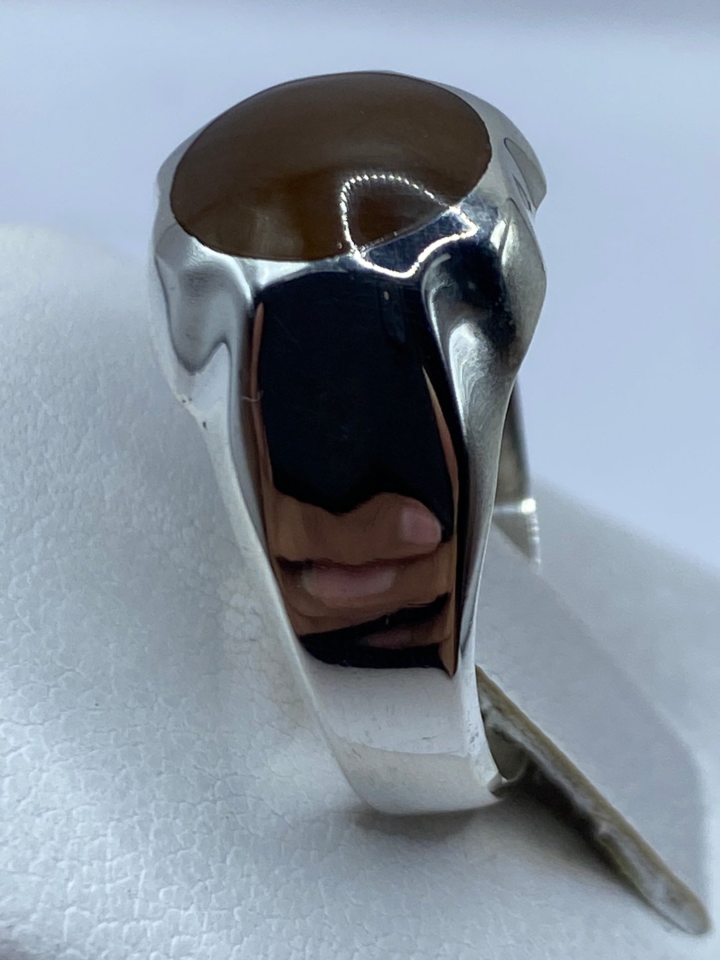Anillo solitario café en dedo, diseño minimalista