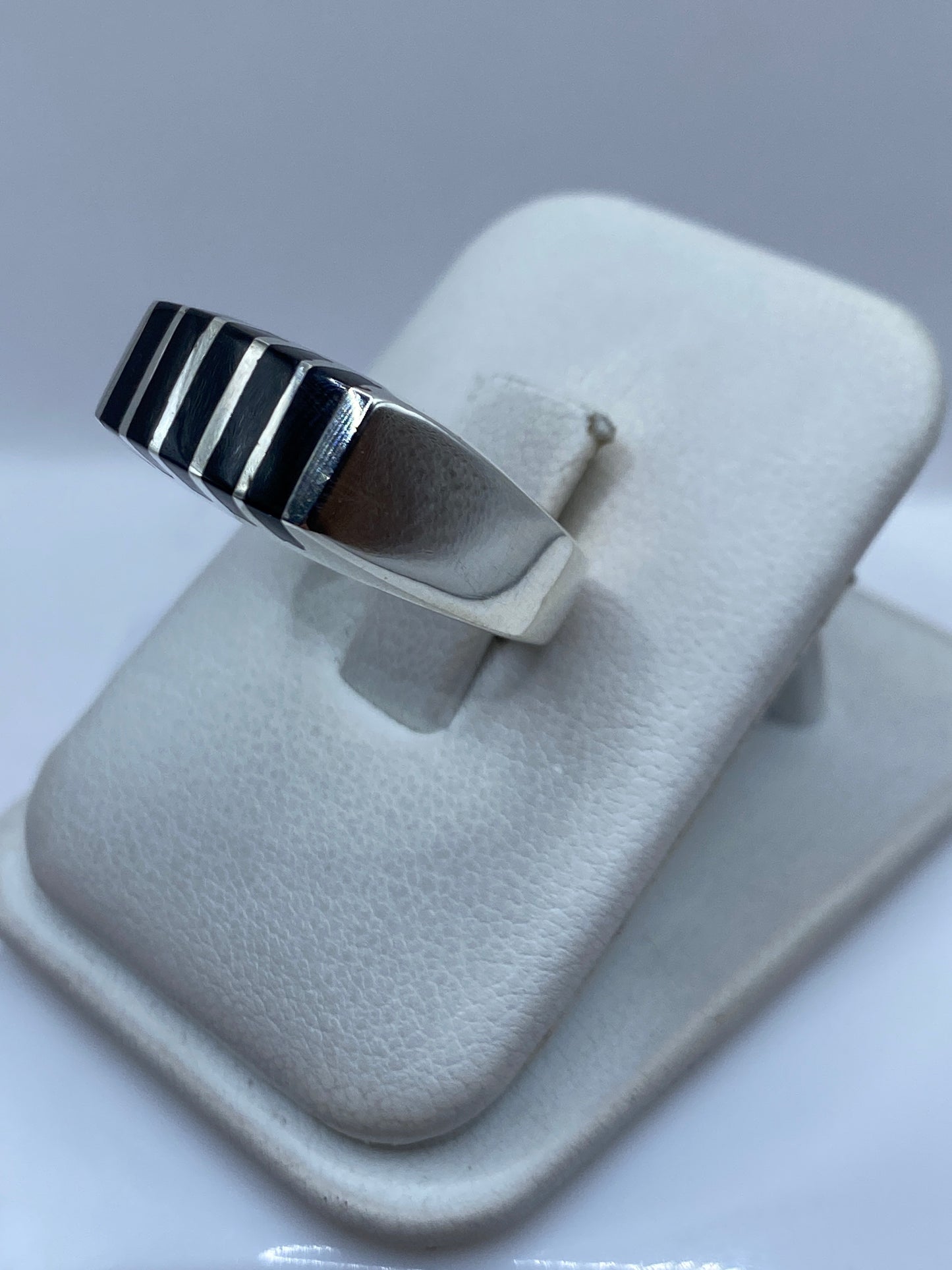 Anillo unisex de ónix negro en plata sobre la mano de una persona