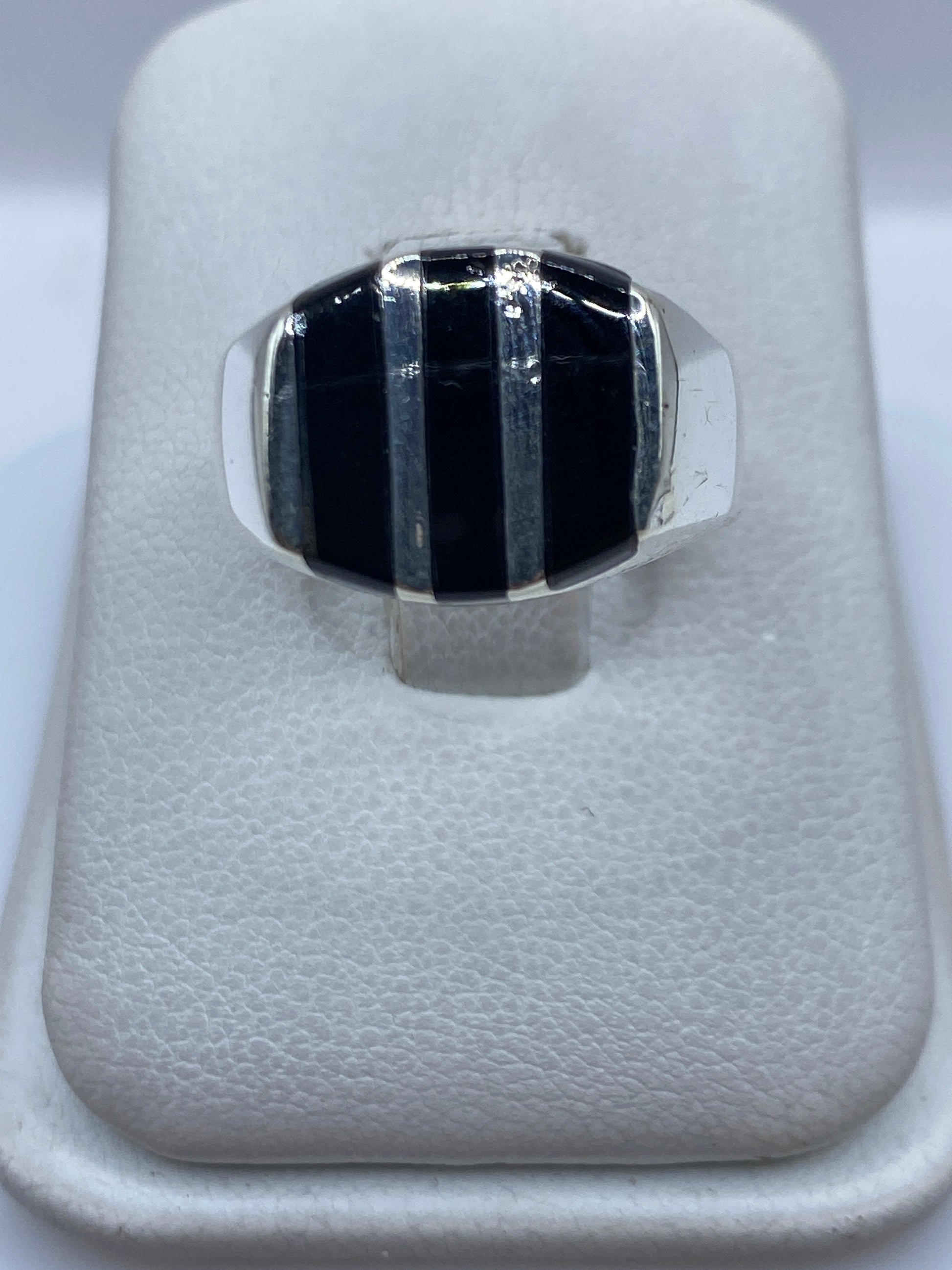 Anillo de plata .925 con ónix negro en diseño geométrico, visto desde arriba en estuche