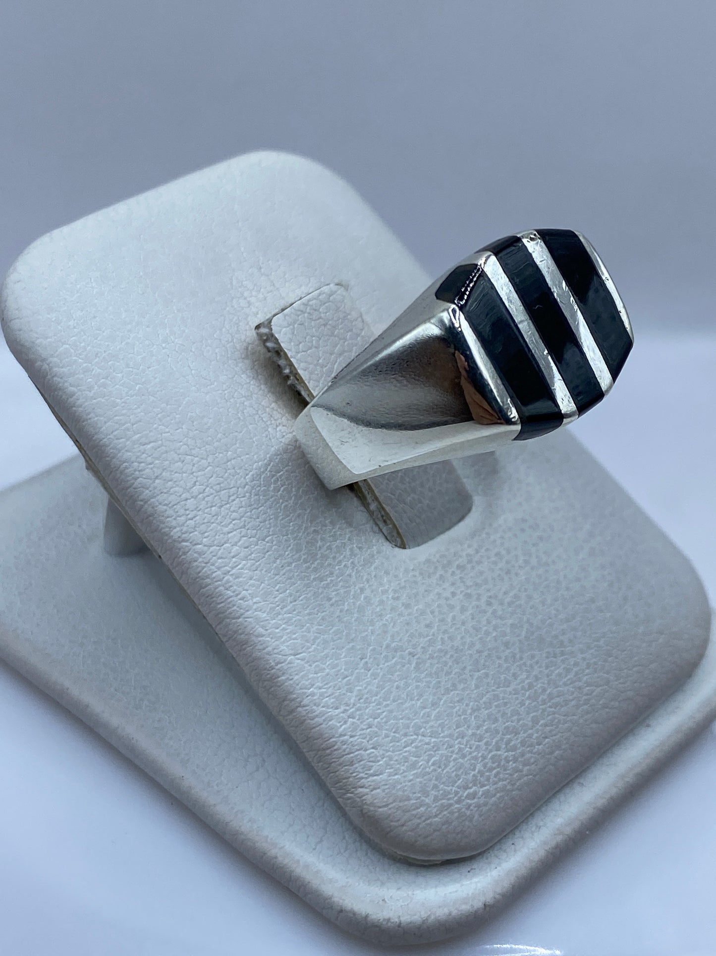 Anillo de plata y ónix puesto en la mano, mostrando las bandas de contraste blanco y negro
