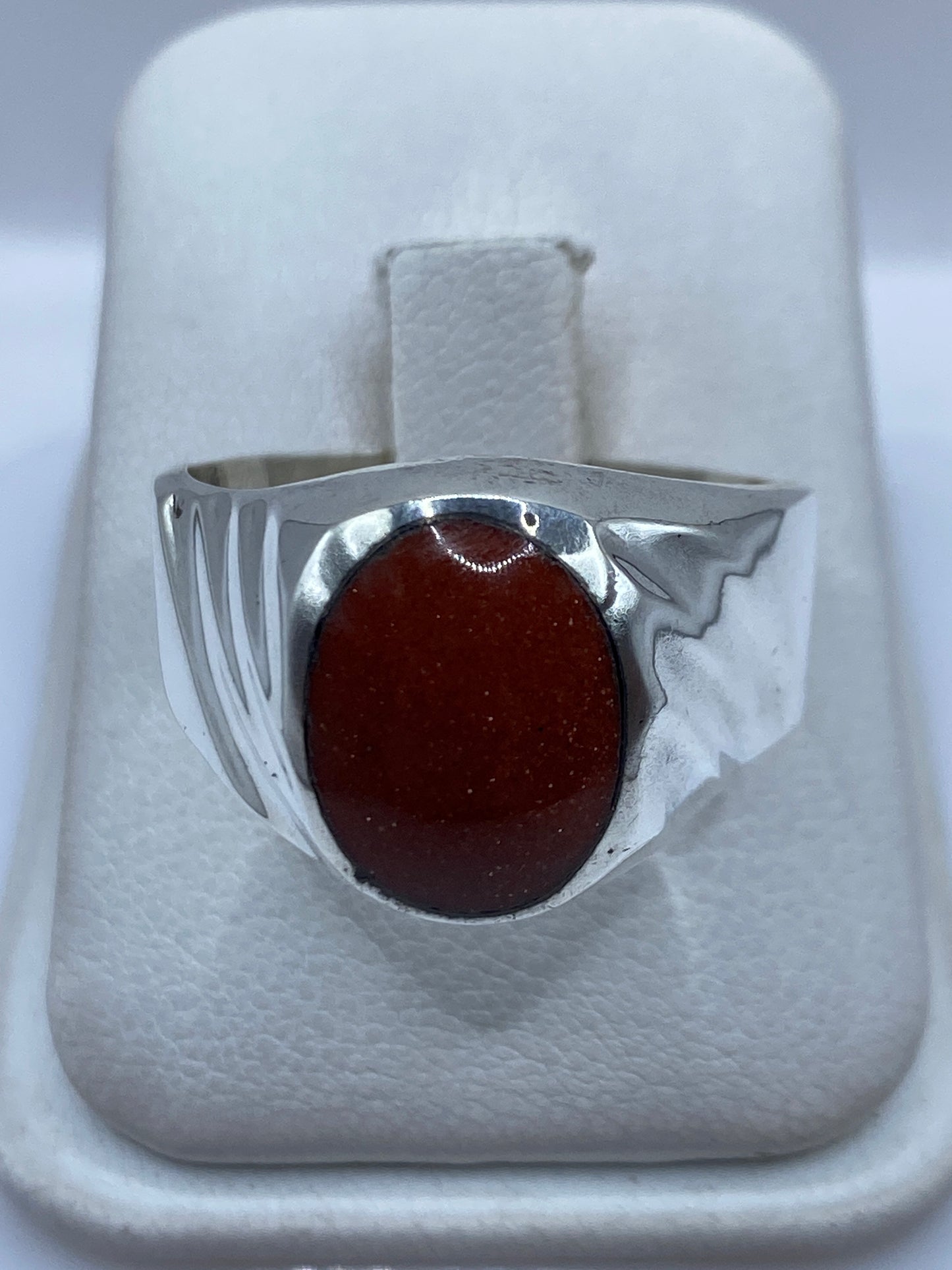 Anillo de plata masivo con piedra engastada, vista frontal sobre dedo