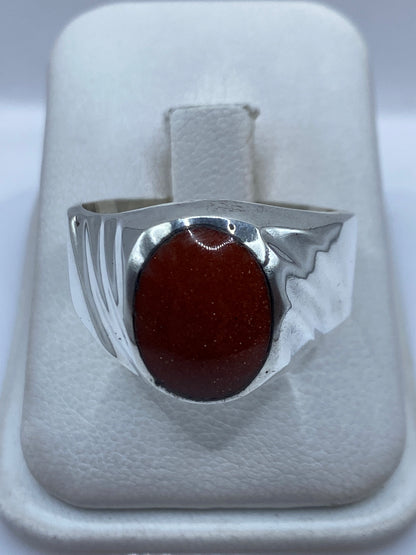 Anillo de plata masivo con piedra engastada, vista frontal sobre dedo