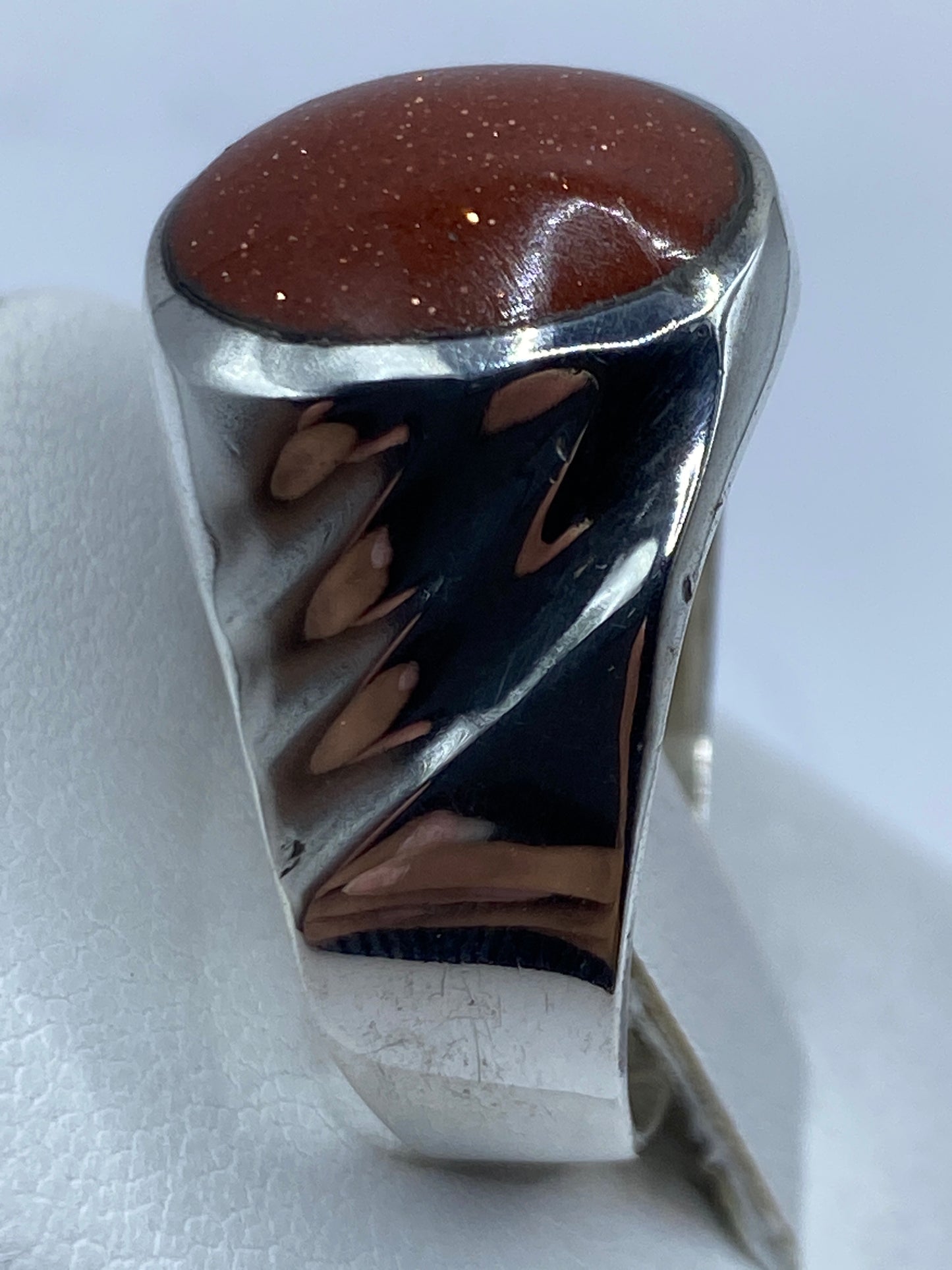 Anillo sobre superficie metal mostrando el peso y solidez de la pieza