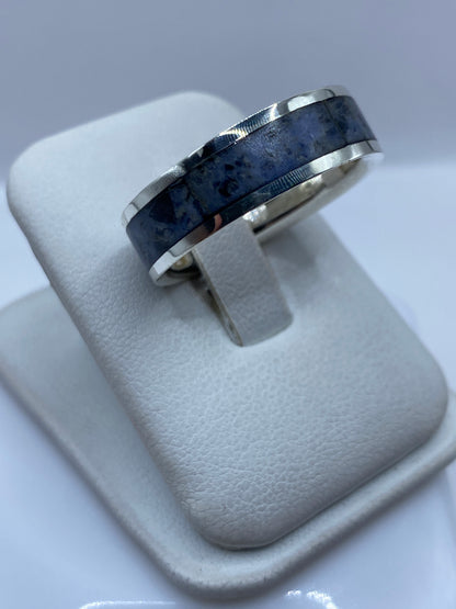 Anillo en dedo mostrando el lapislázuli azul profundo y las bandas de plata pulida