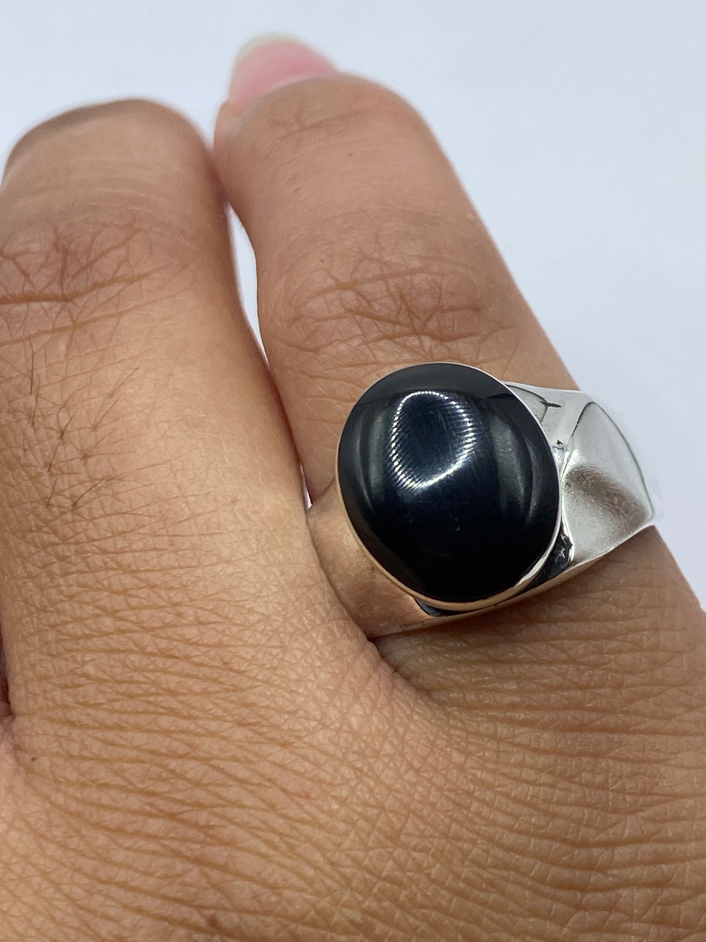 Anillo en el dedo mostrando el contraste entre la plata y la piedra negra