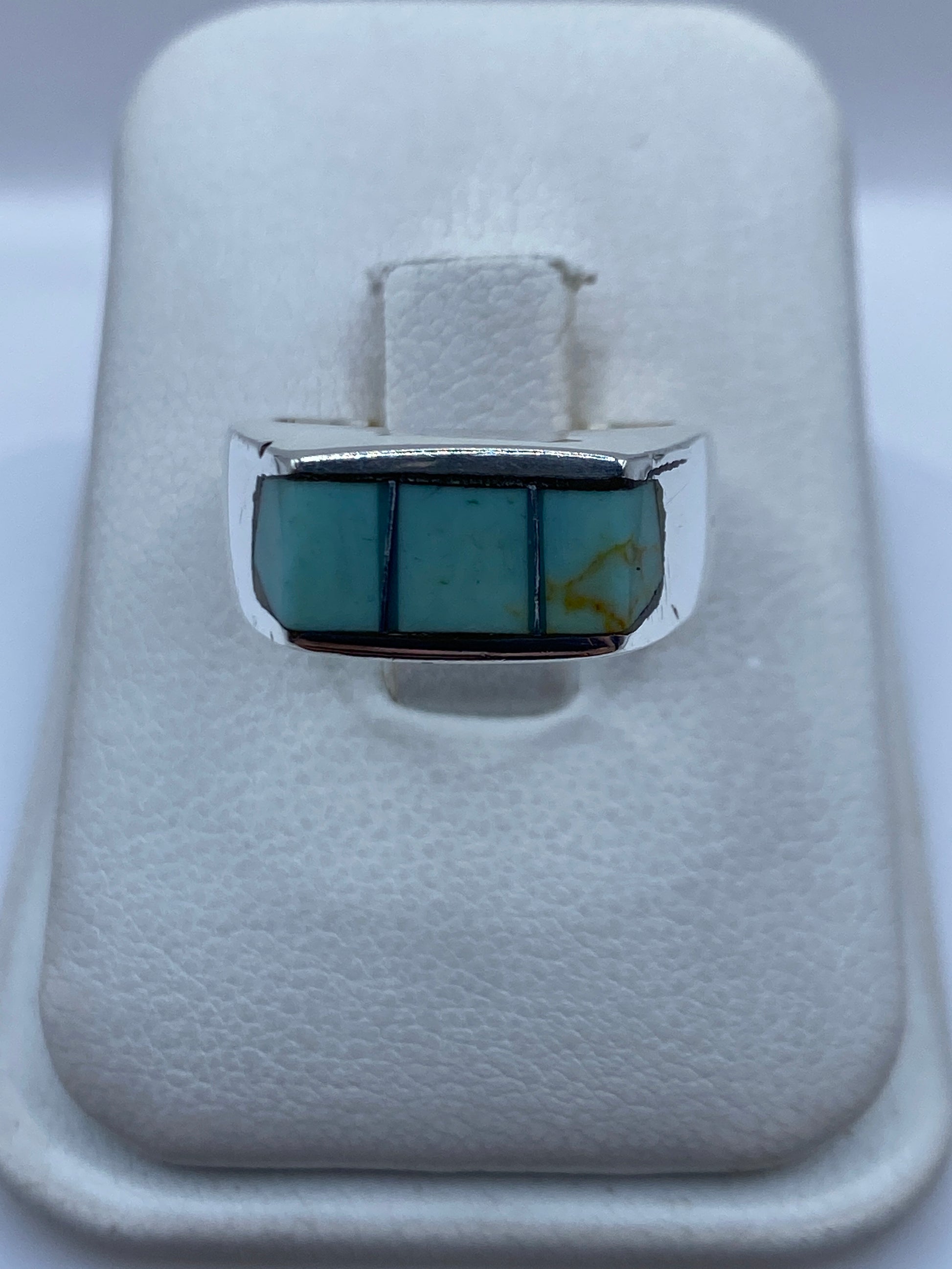 Anillo de plata .925 con tres bloques de turquesa azul cielo engastados en línea, sobre fondo blanco