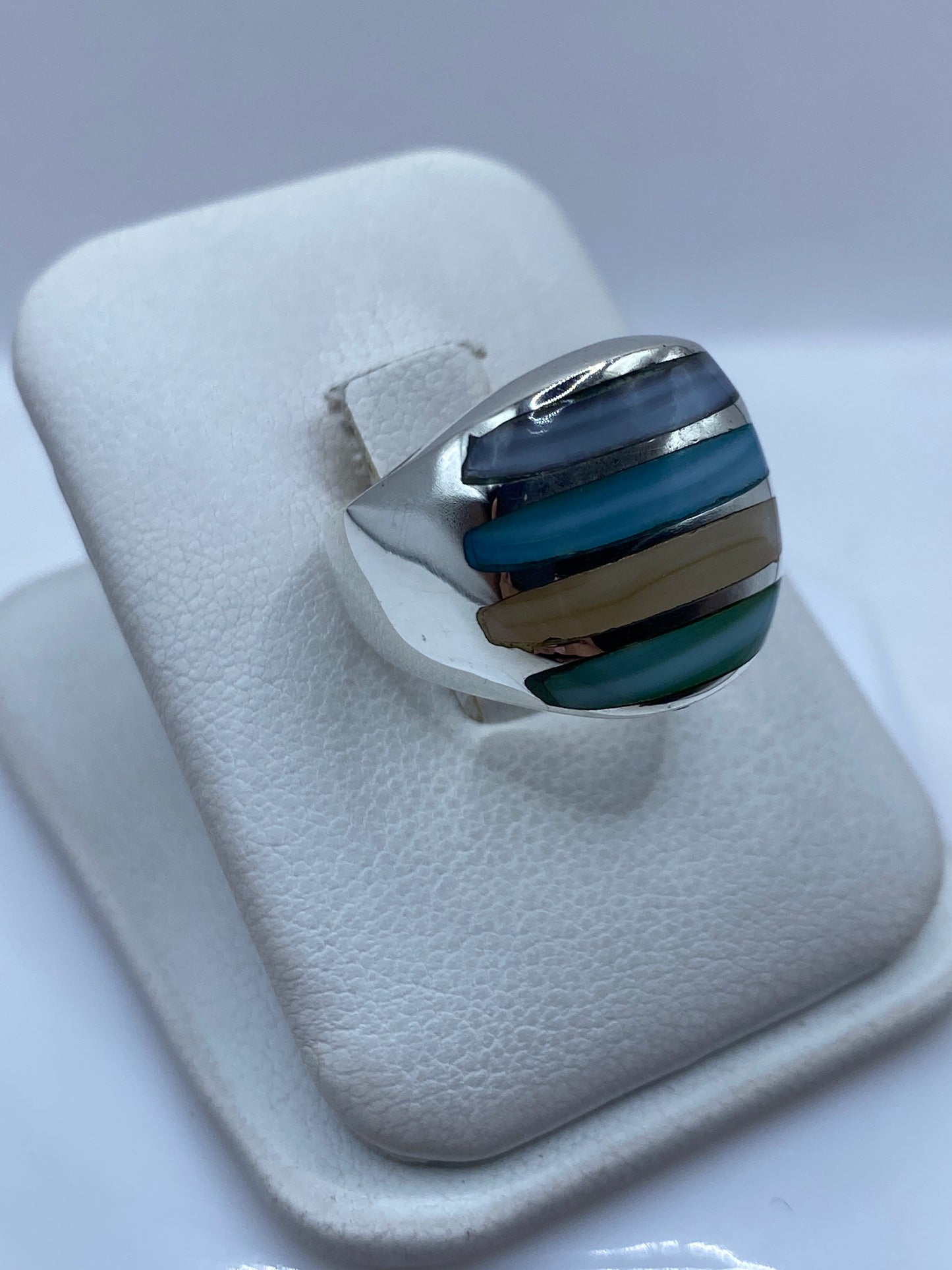 Detalle de las piedras azul, verde y beige engastadas a mano en la plata