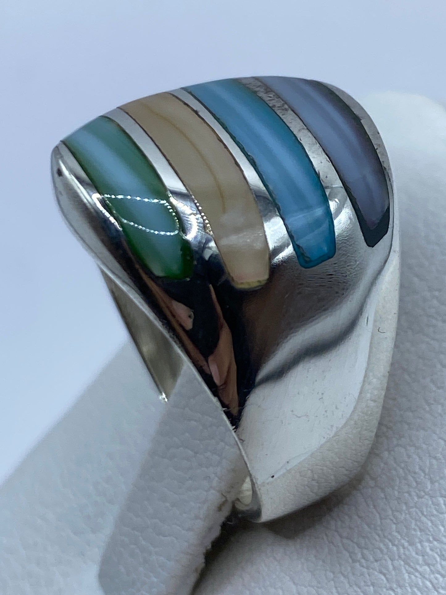 Anillo puesto en un dedo mostrando los tonos multicolor a la luz