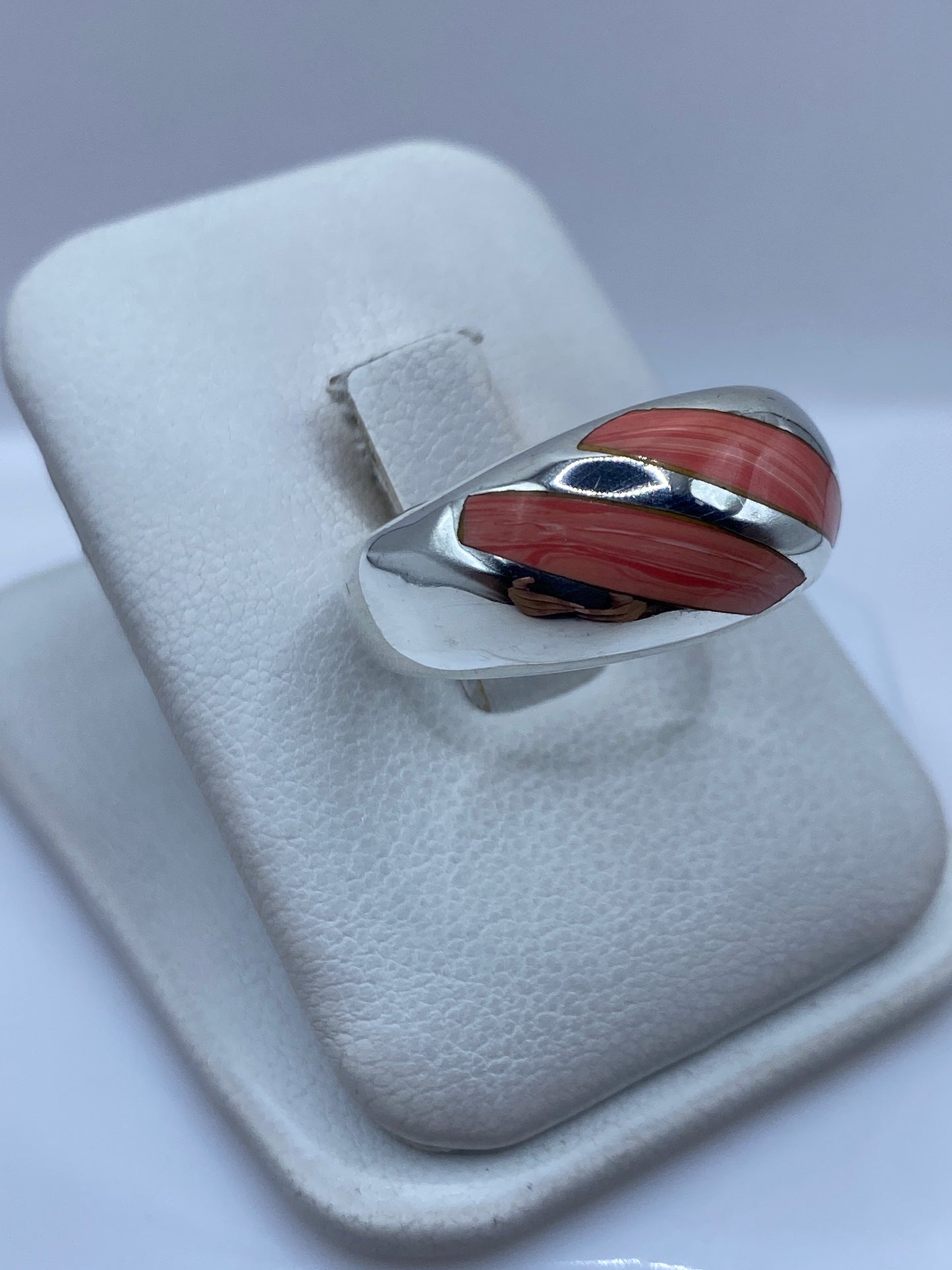 Anillo de coral y plata Taxco en el dedo, mostrando la faceta y el brillo del coral