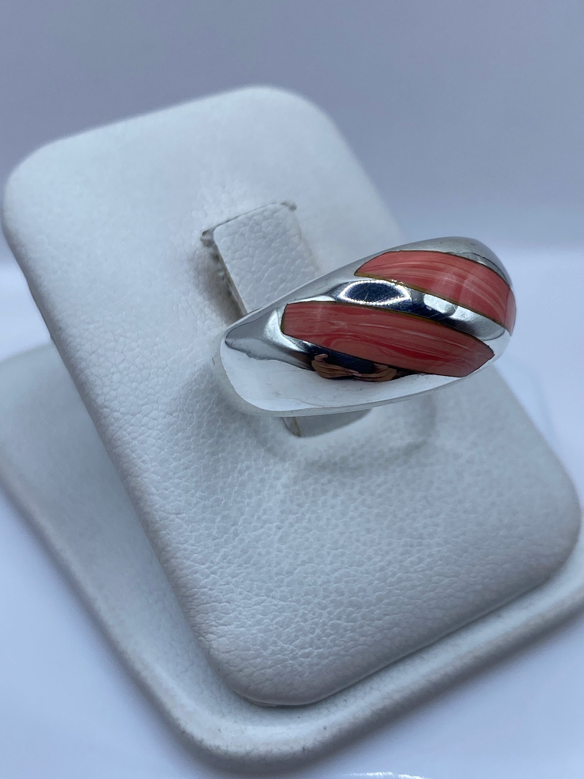 Anillo de coral y plata Taxco en el dedo, mostrando la faceta y el brillo del coral