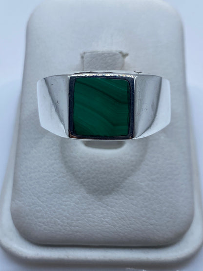 Anillo de plata sello con malaquita verde engastada, visto de frente en joyero blanco