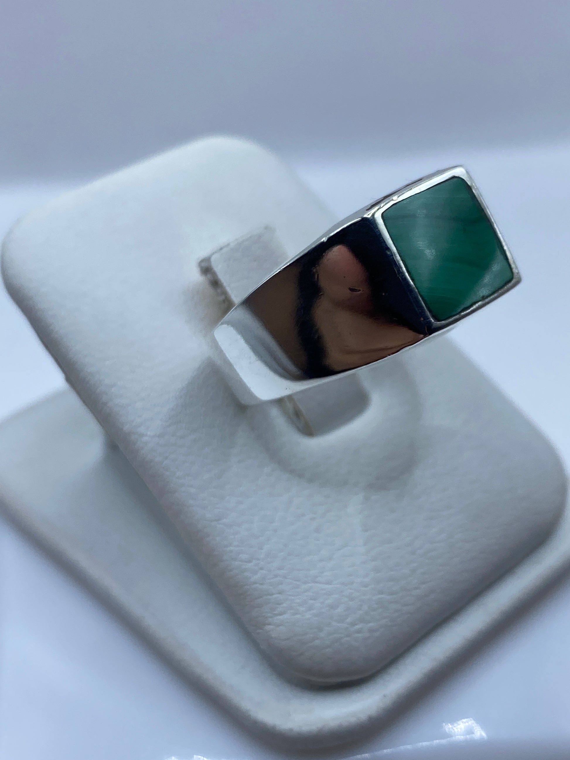 Detalle de la malaquita verde con vetas naturales en el engaste de plata .925
