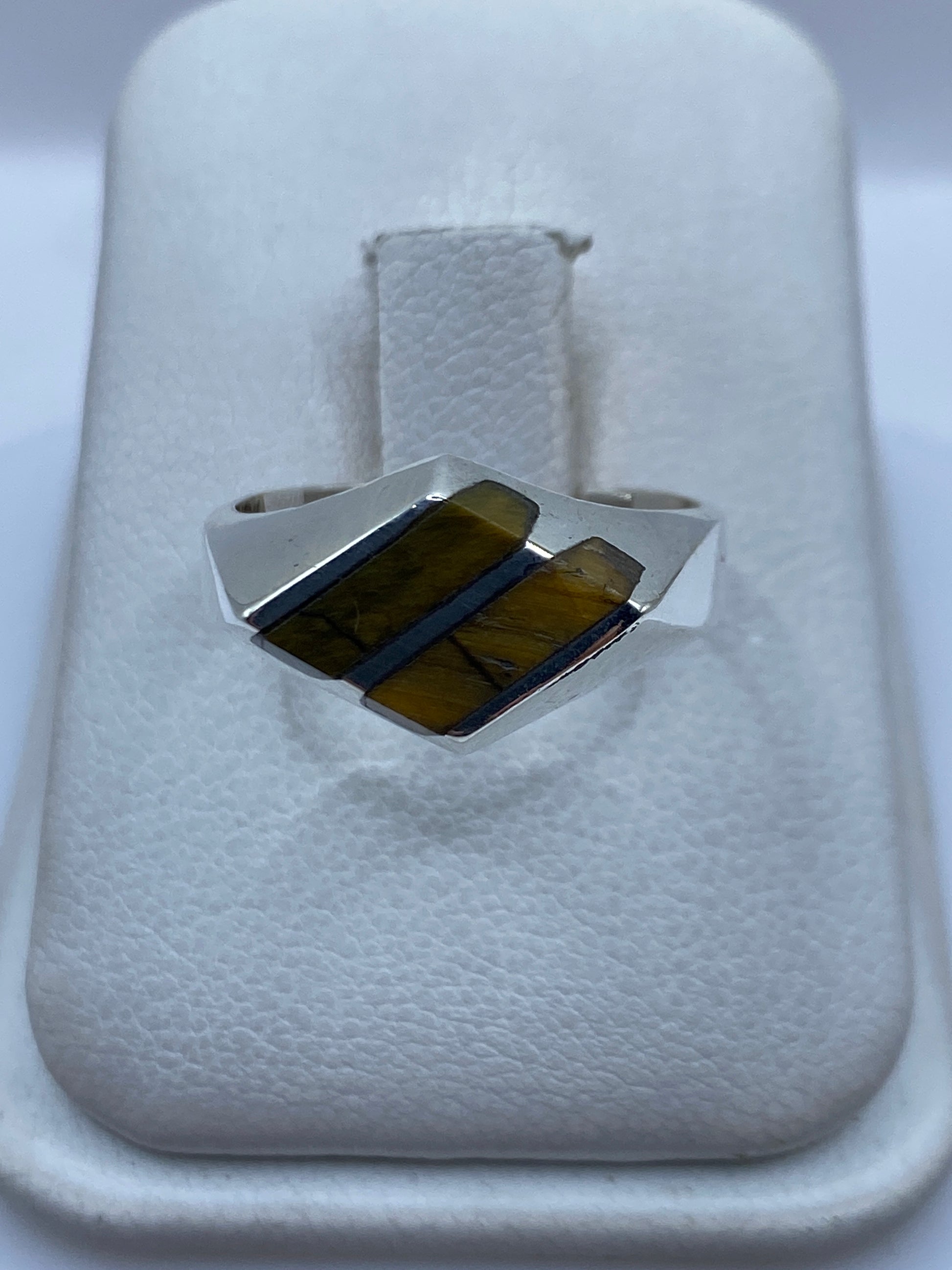 Anillo de plata con piedra café engastada a mano, vista frontal sobre fondo blanco