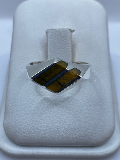 Anillo de plata con piedra café engastada a mano, vista frontal sobre fondo blanco
