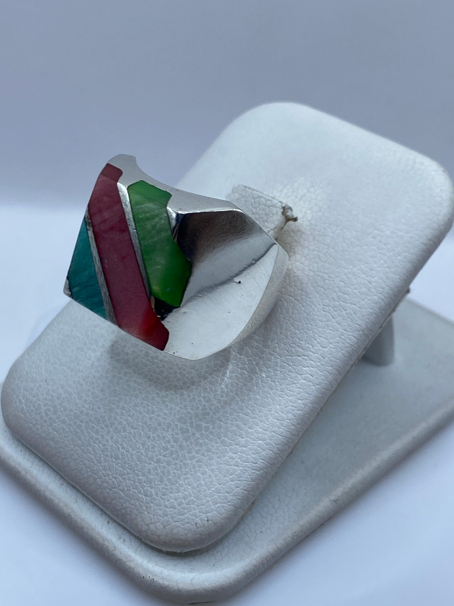 Detalle lateral del anillo mostrando el engaste individual de cada piedra y la banda de plata pulida