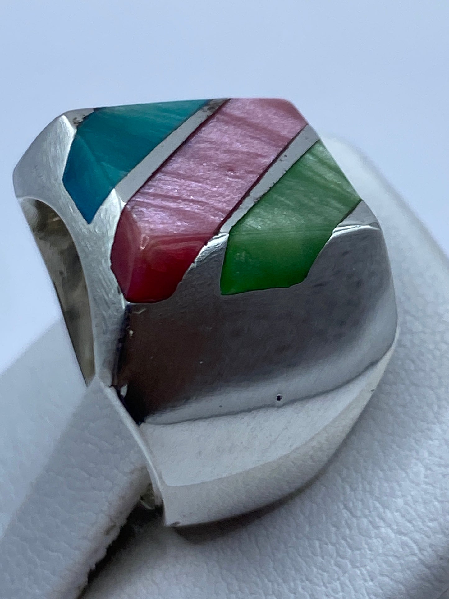 Anillo de incrustación geométrica puesto en la mano mostrando cómo brillan las piedras con el movimiento