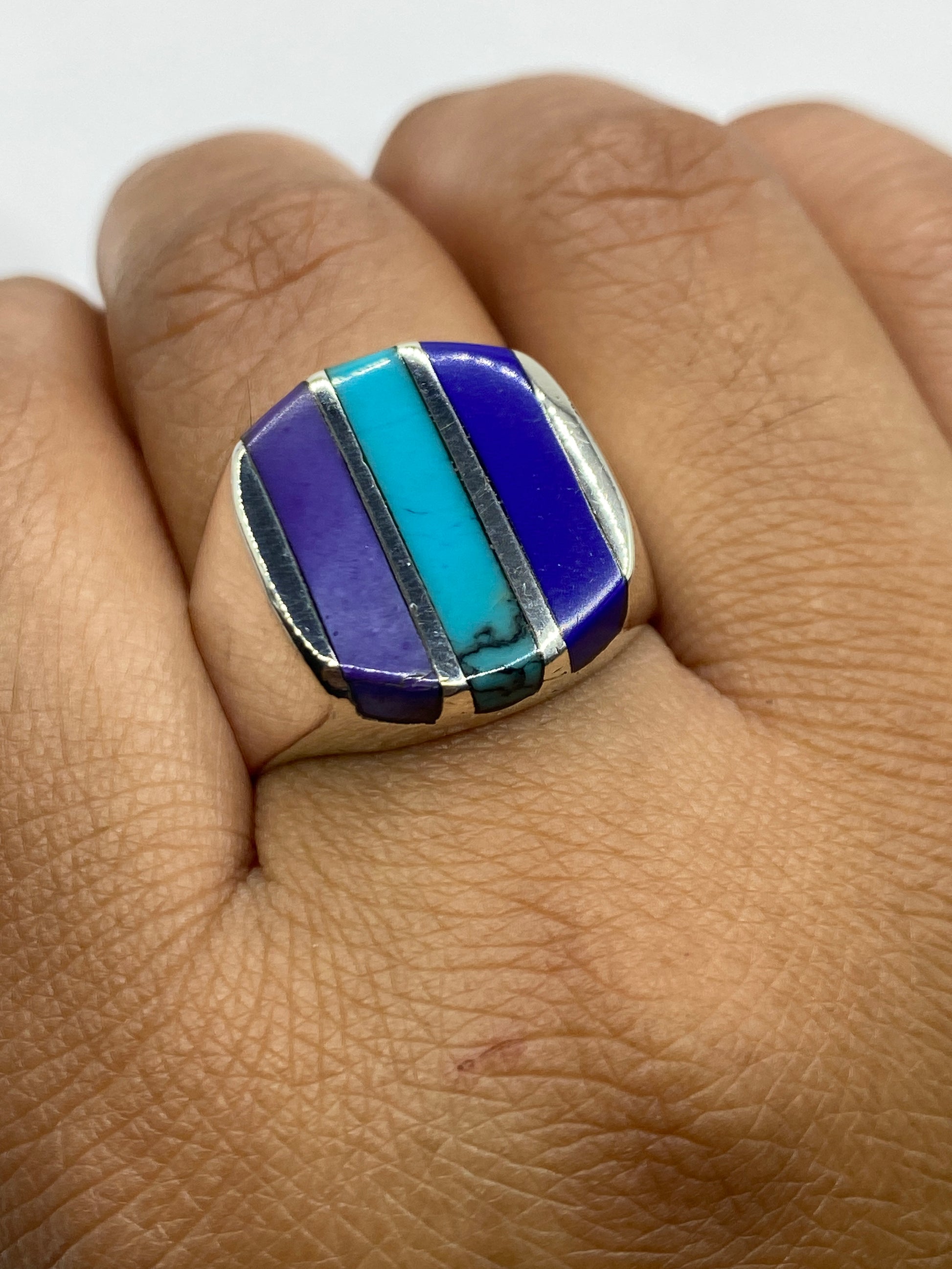 Anillo de plata en la mano de un hombre, turquesa azul cielo brillando en la luz natural