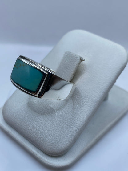 Anillo de turquesa en mano, mostrando el engaste a mano y el pulido de la plata