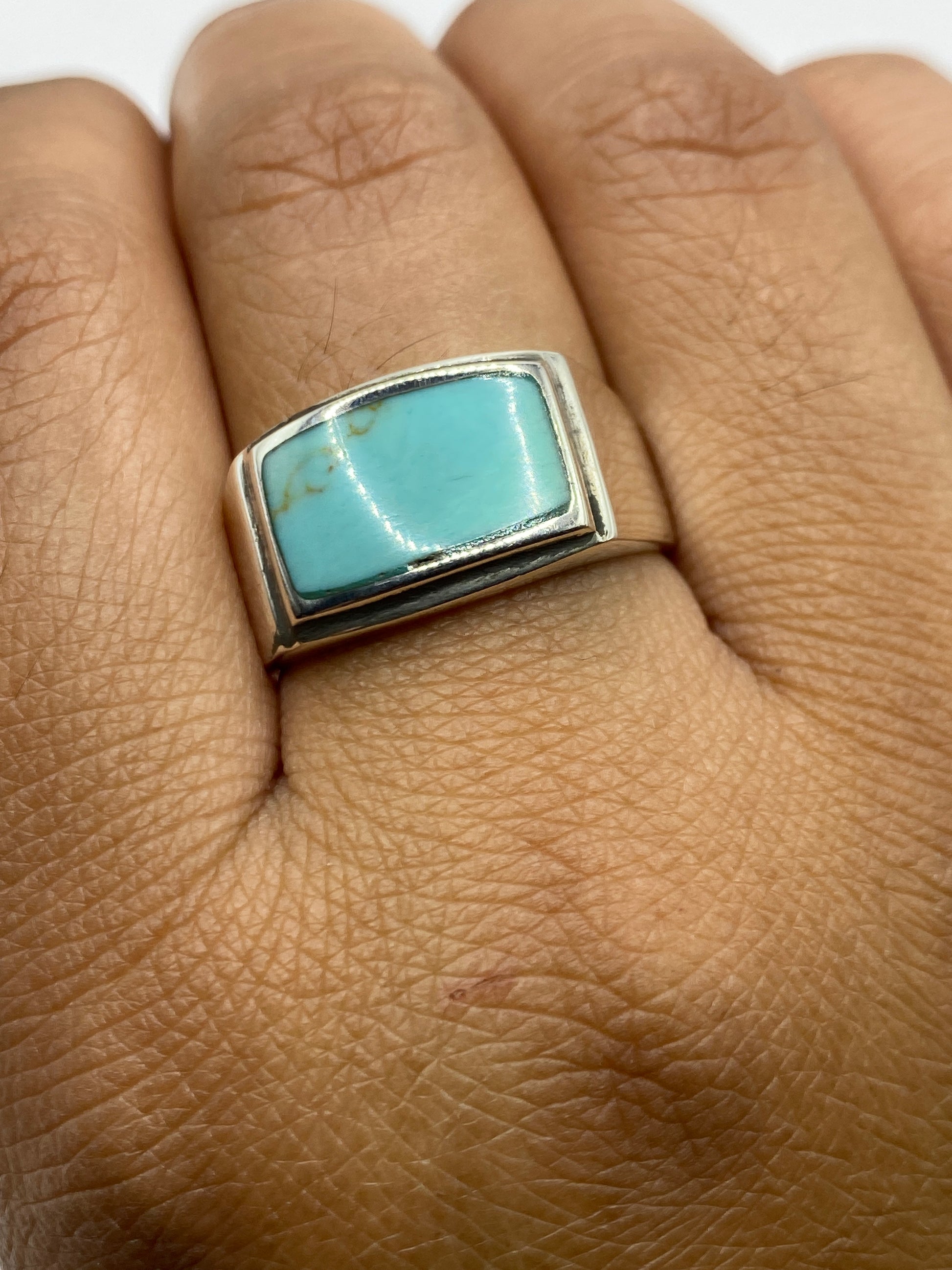 Anillo sobre fondo gris, mostrando el tono azul cielo de la turquesa