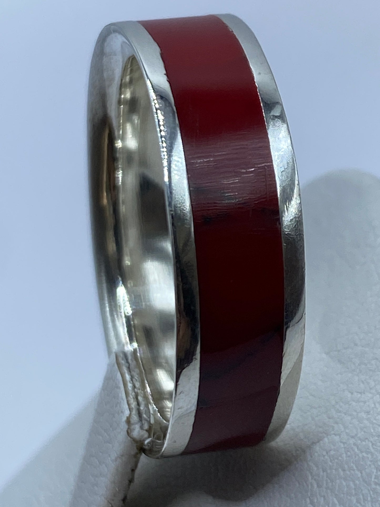 Anillo de coral rojo en plata en la mano de un hombre, uso diario