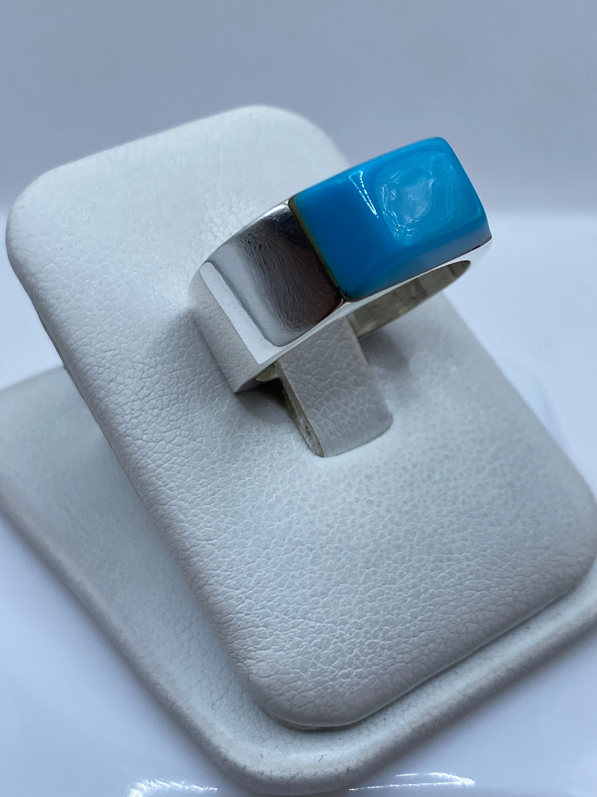 Detalle lateral del anillo mostrando el engaste a mano de la turquesa y la plata pulida