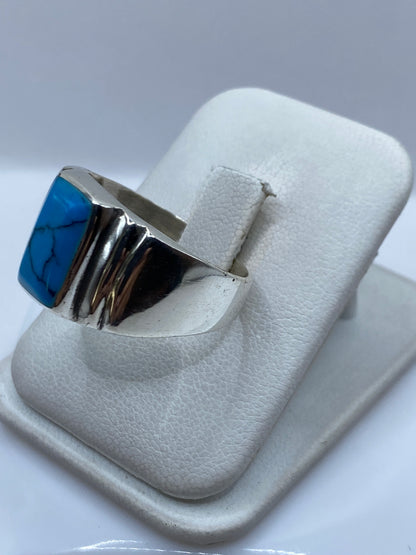 Anillo de turquesa en mano de hombre, mostrando el engaste y el acabado pulido