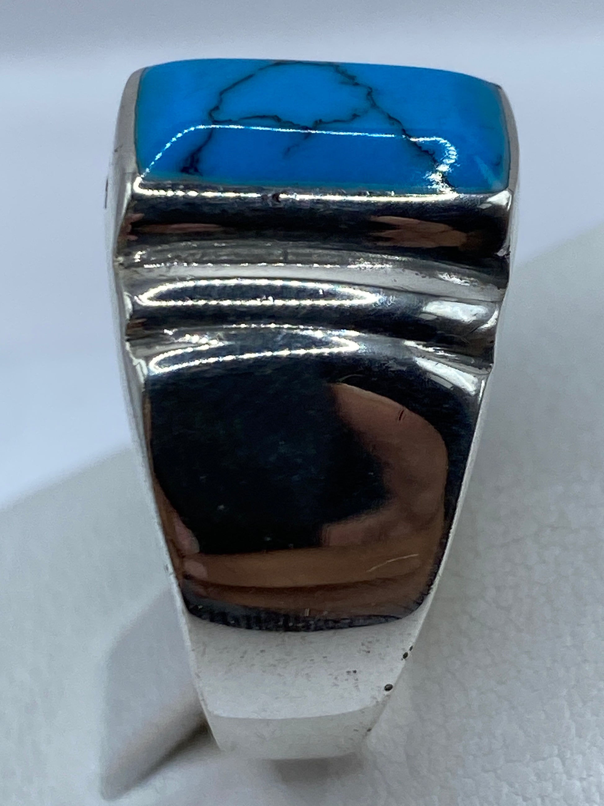 Detalle lateral del anillo: banda ancha de plata con la turquesa azul cielo engastada