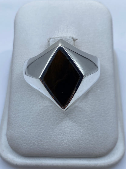 Anillo de plata solitario con piedra cafe engastada a mano, vista frontal en estuche