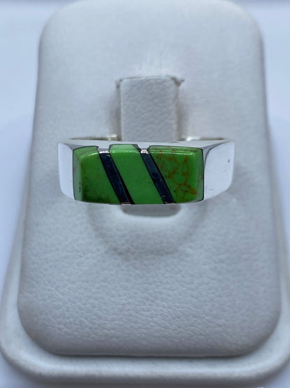 Anillo de plata con piedra verde engastada en diseño geométrico, vista frontal