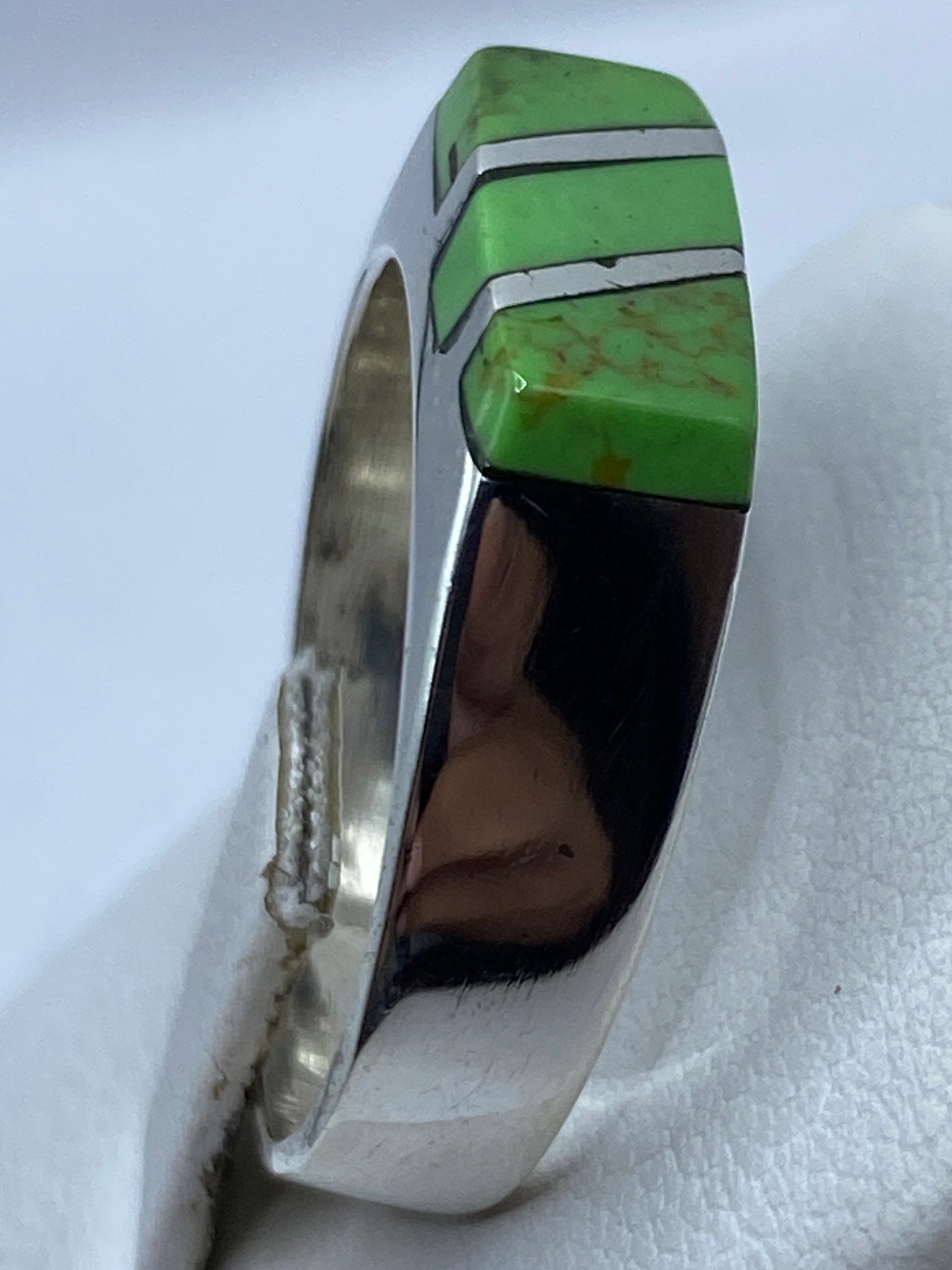 Anillo unisex con piedra verde natural en plata, vista lateral mostrando el peso y construcción
