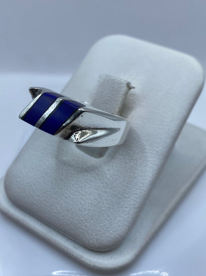 Anillo de plata con piedra azul vista lateral en dedo, diseño moderno versátil