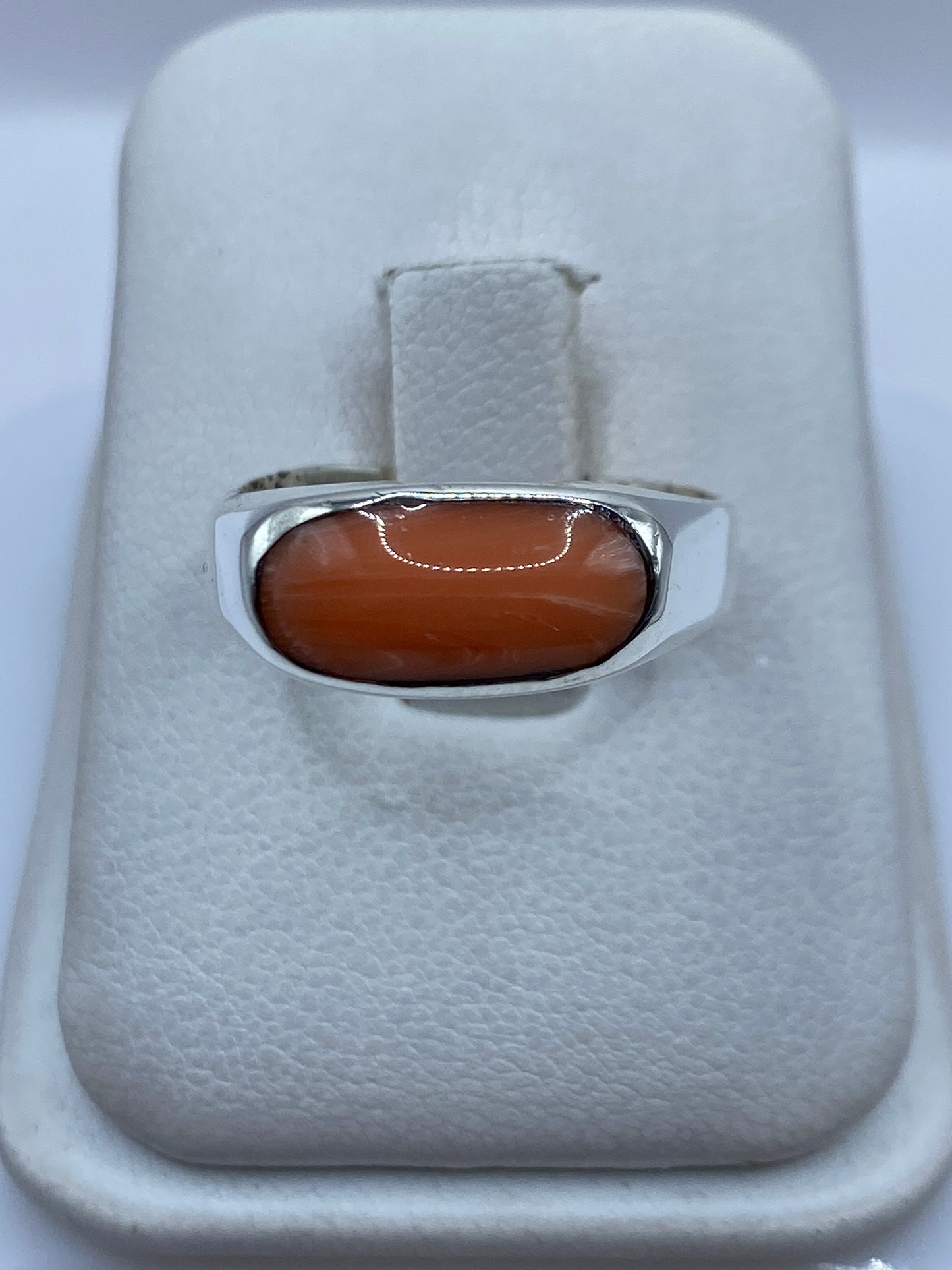 Anillo de plata .925 con coral natural engastado, sobre dedo de mujer