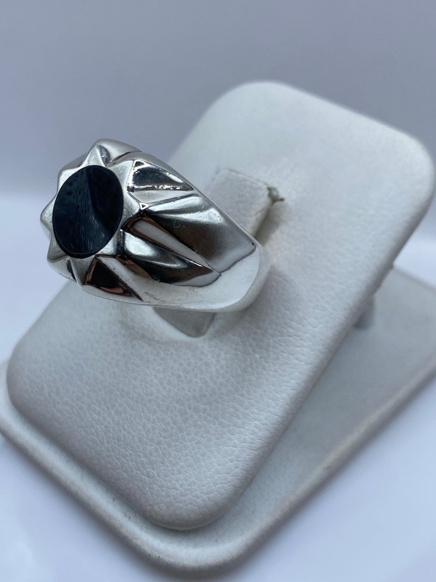 Anillo de plata ónix negro en la mano mostrando el engaste estructurado