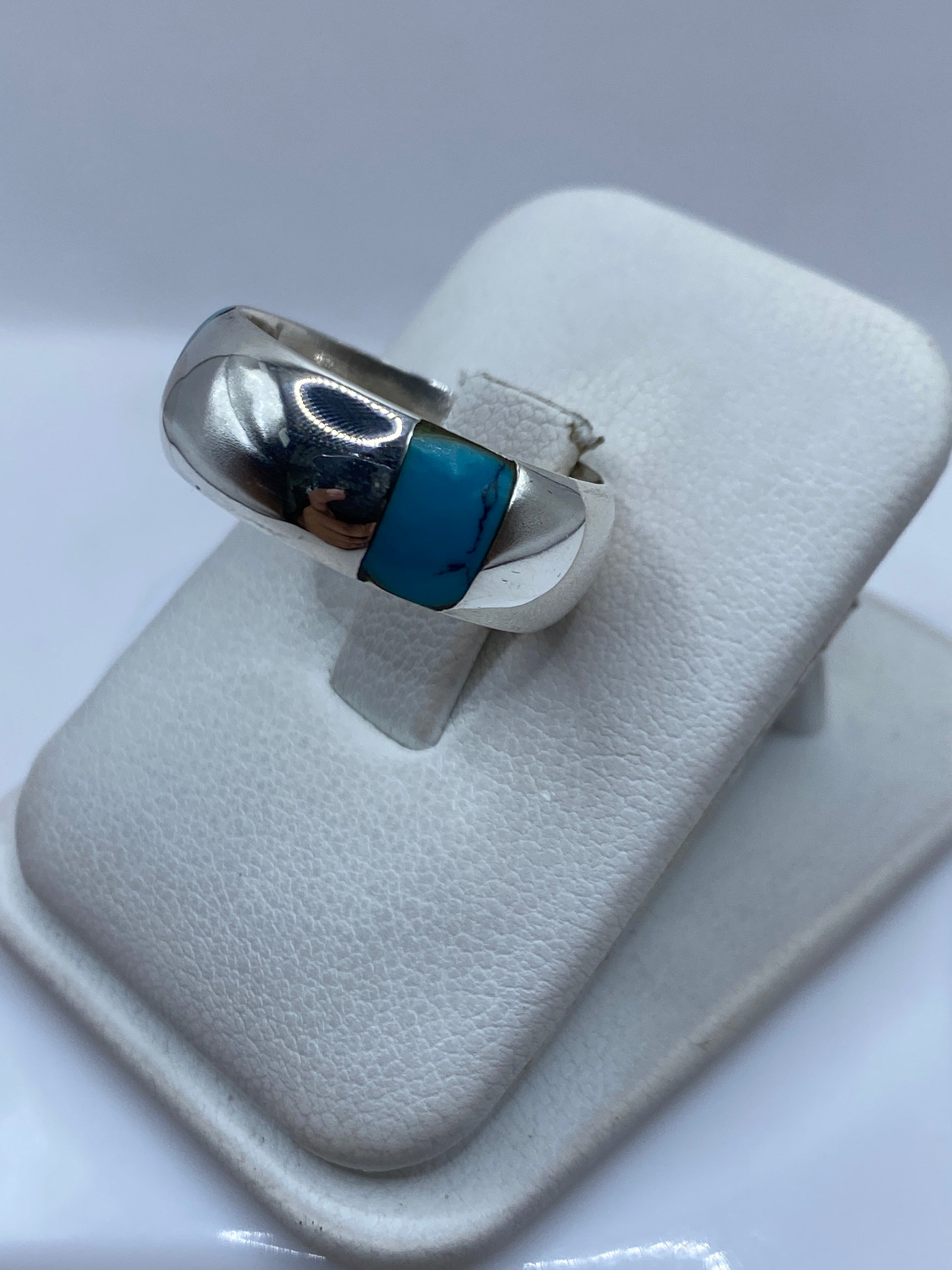 Detalle frontal del engaste de turquesa en anillo de banda pulida