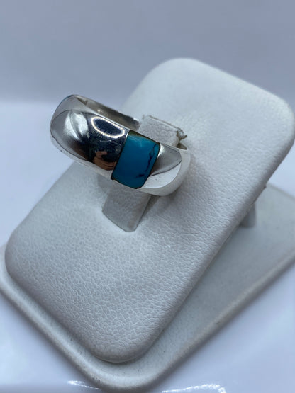 Detalle frontal del engaste de turquesa en anillo de banda pulida