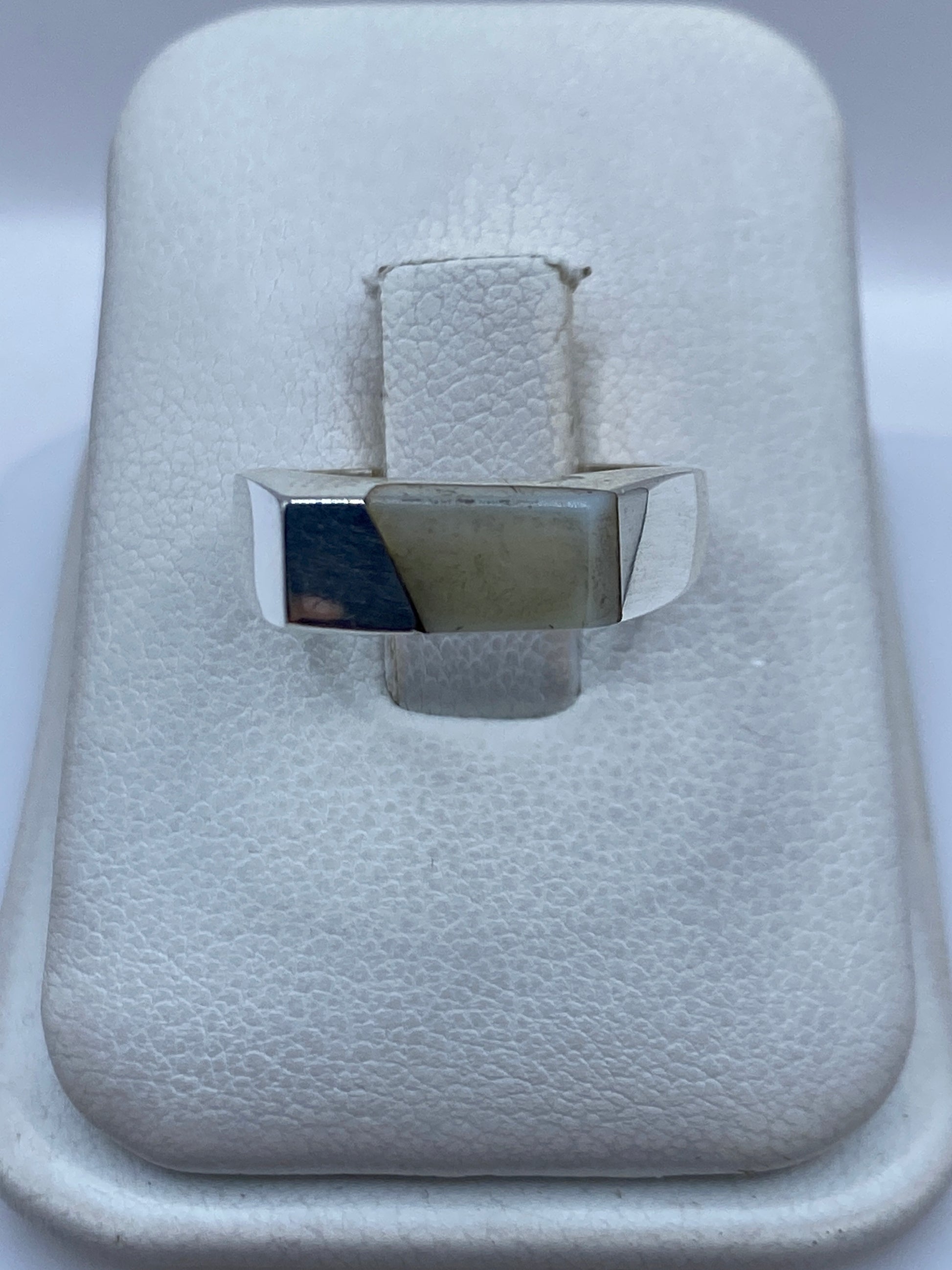 Anillo de plata .950 con perla blanca engastada en la mano de una mujer