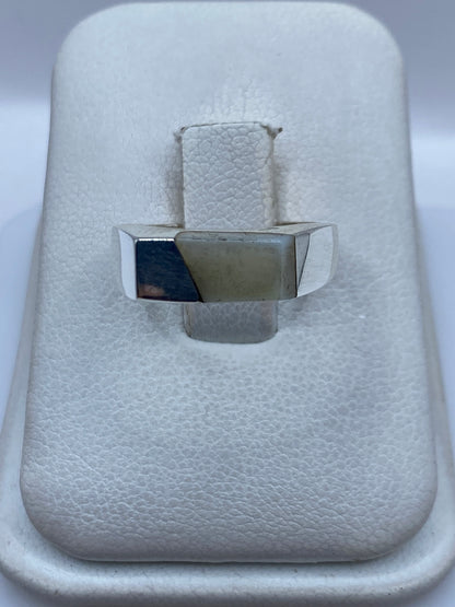 Anillo de plata .950 con perla blanca engastada en la mano de una mujer