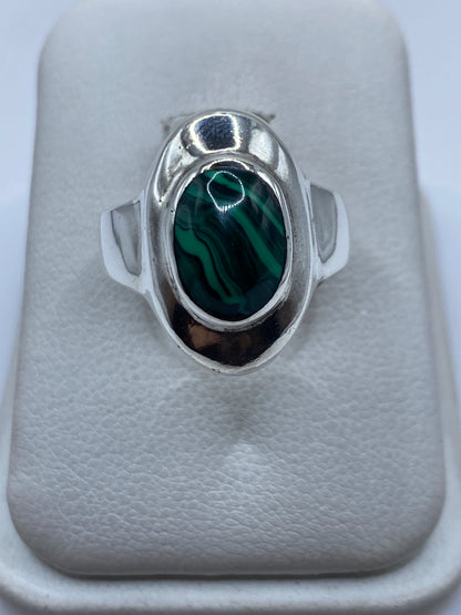 Anillo de plata .925 con malaquita verde natural engastada en la mano de una mujer
