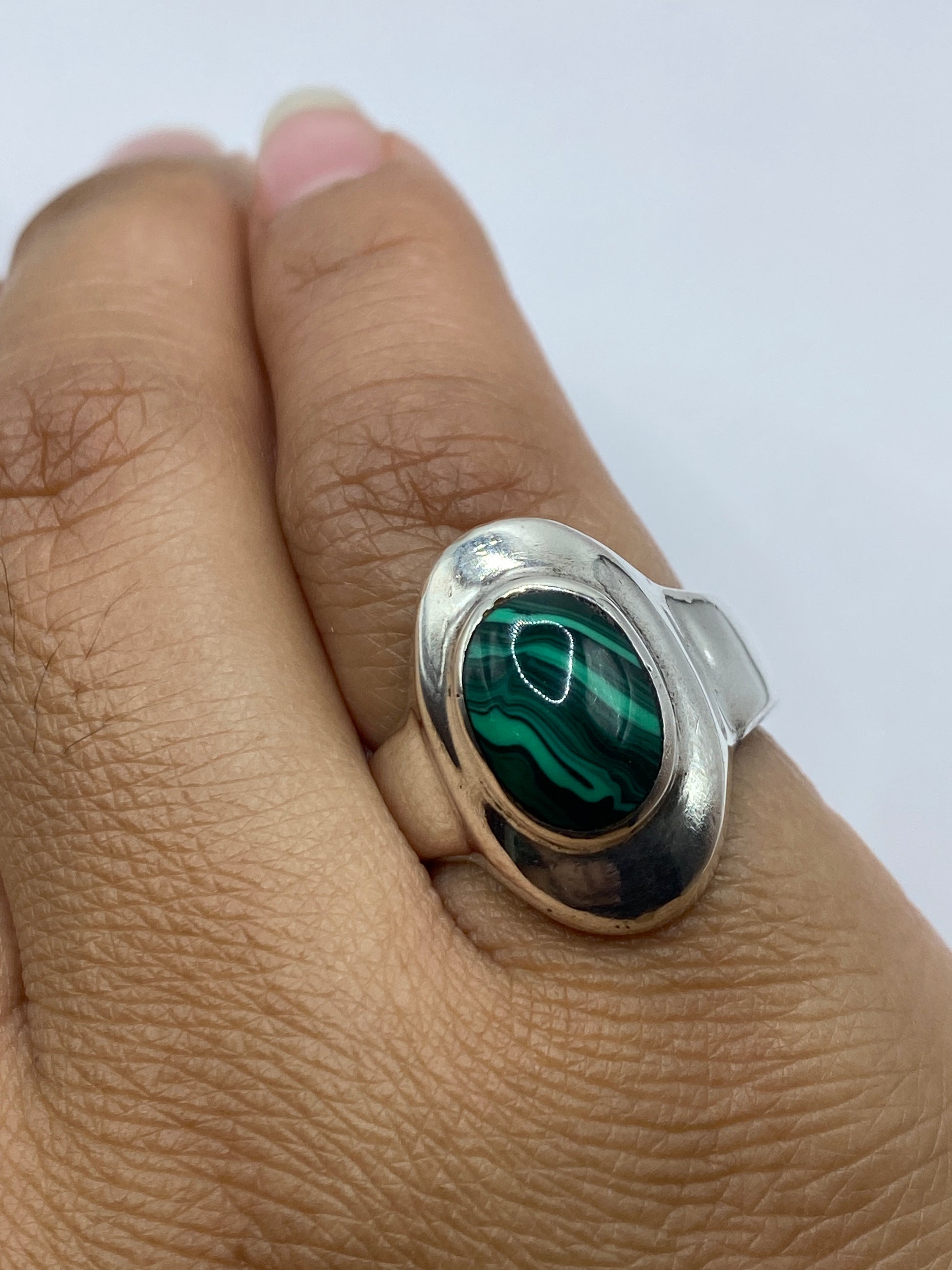 Anillo sobre superficie blanca, vista superior con la malaquita en primer plano