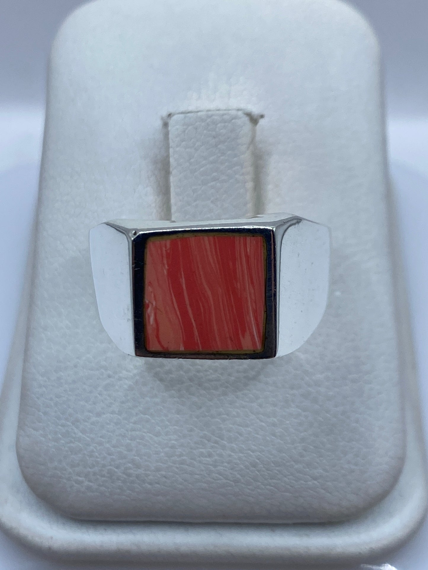 Anillo de plata .925 con coral rojo intenso engastado, vista frontal en estuche blanco