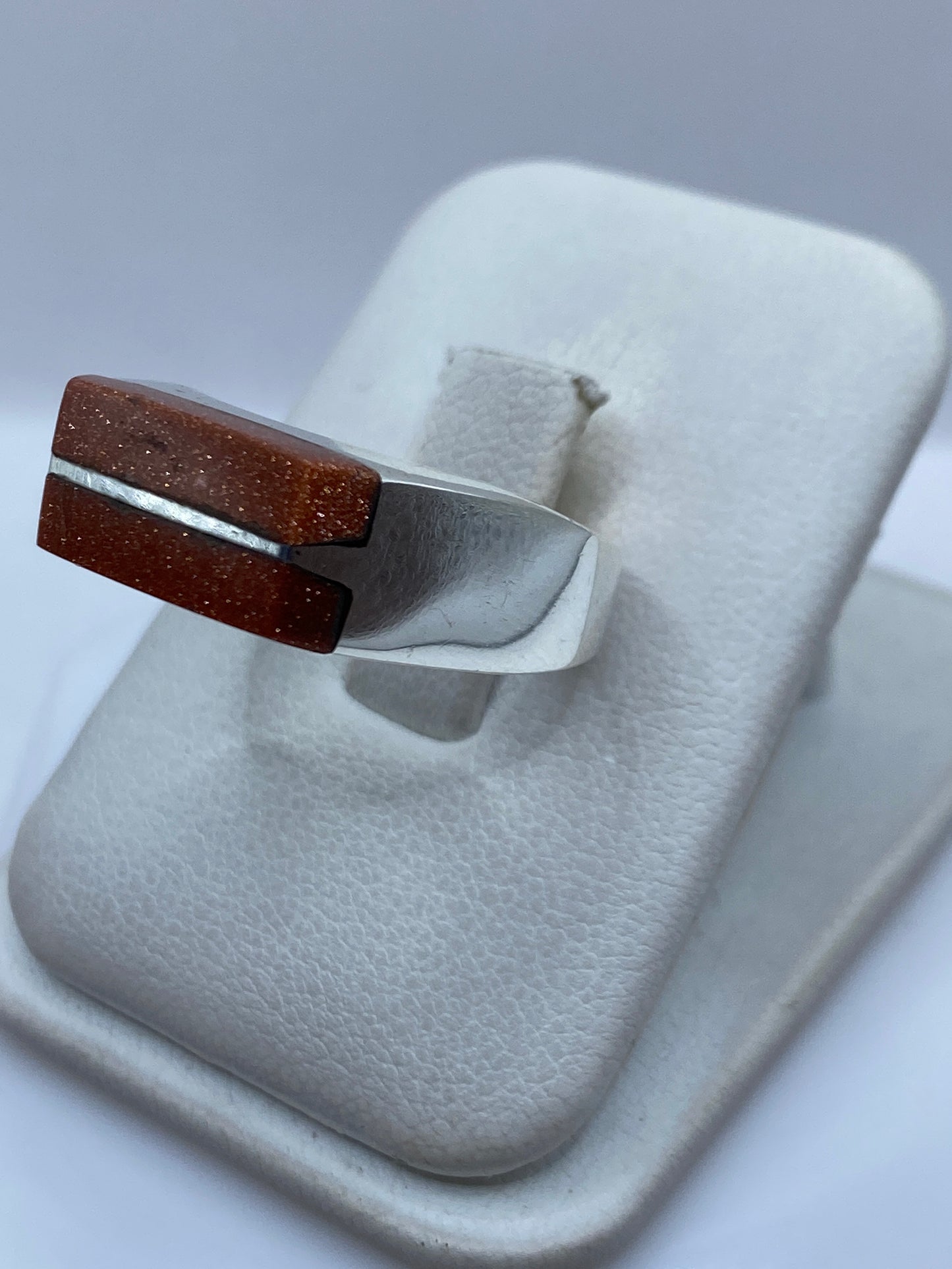 Detalle lateral del anillo mostrando el engaste limpio y la banda pulida de plata