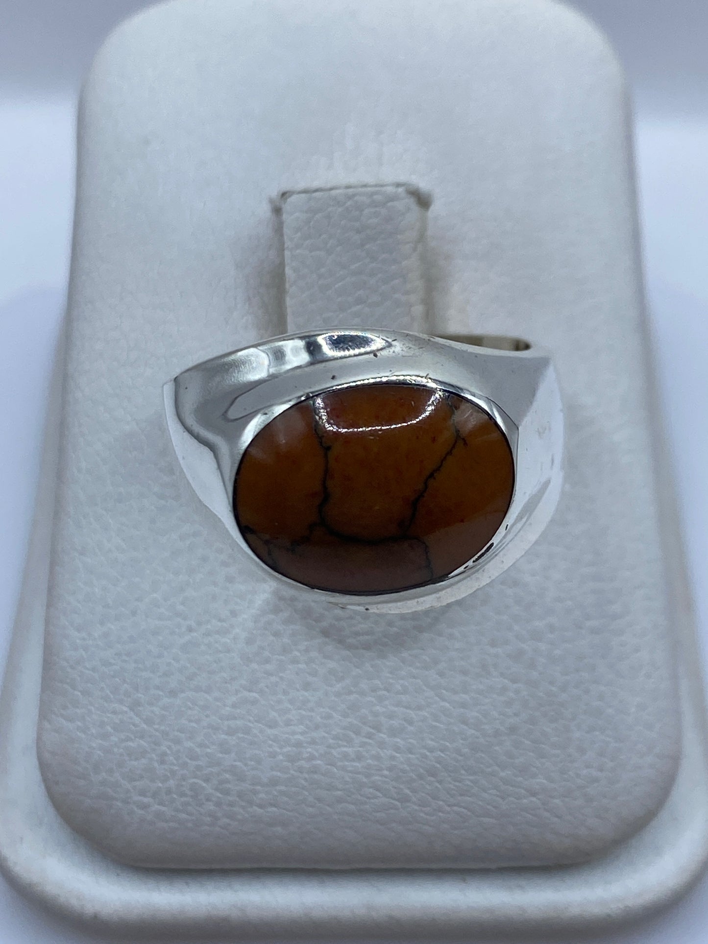 Anillo de plata .925 con piedra café engastada, visto de frente en estuche blanco