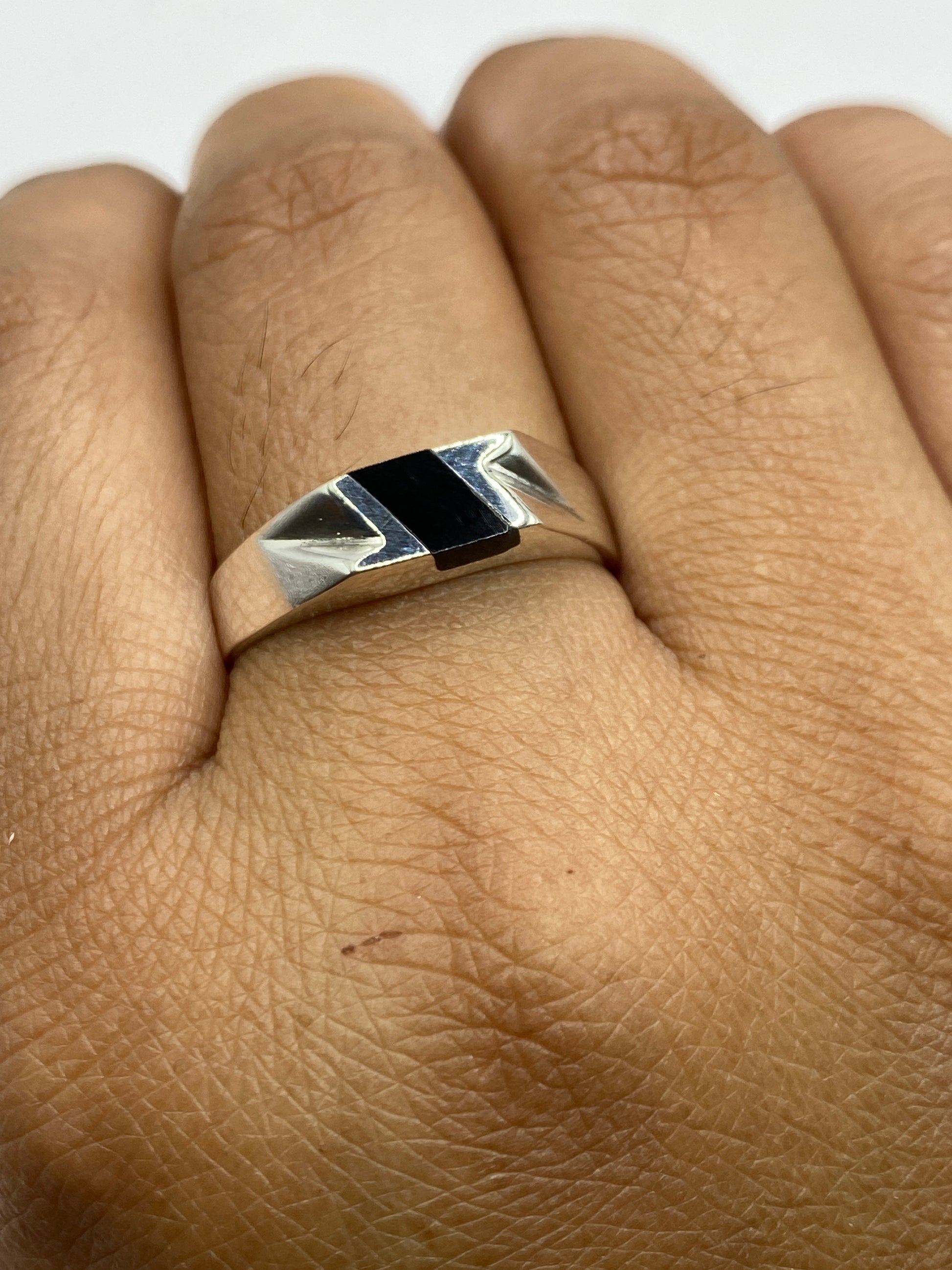 Anillo en dedo mostrando el contraste entre la piedra negra y la plata brillante