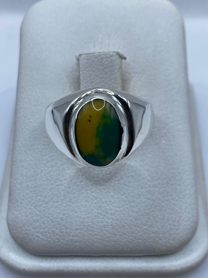 Anillo de plata .925 con piedra amarilla engastada, vista frontal sobre cojín blanco