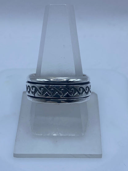 Anillo spinner de plata .925 con volutas ola grabadas puesto en la mano — antiestrés artesanal hecho a mano en Taxco