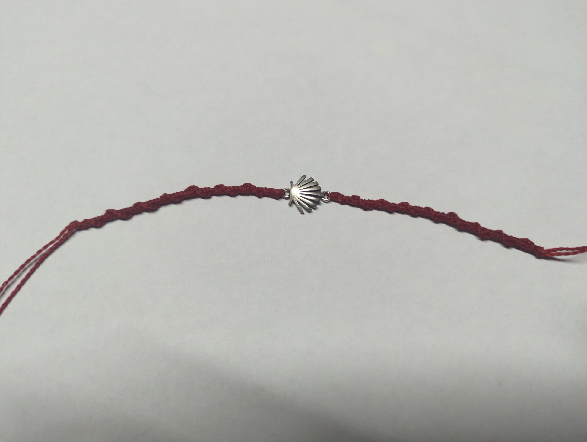 Pulsera ajustable con dije de concha en plata .925 y cordón bordo trenzado